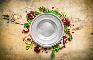 Empty the bowl of pomegranate seeds and leaves around. photo