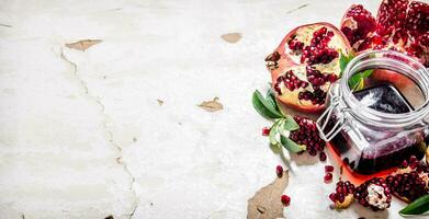 Pomegranate juice with bits of pomegranates and leaves. photo