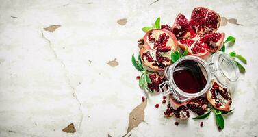 Pomegranate juice with bits of pomegranates and leaves. photo