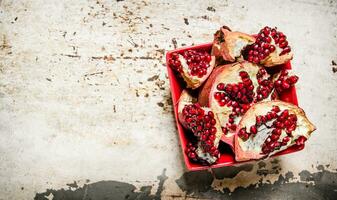 Fresh pomegranate in a cup. On rustic background. photo