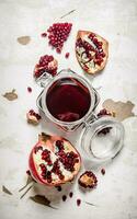 Pomegranate juice in a jar with pieces of ripe pomegranate. photo