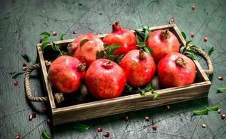 Fresh pomegranates on a wooden tray. photo