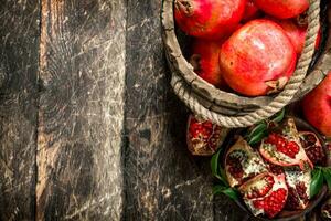 Fresh pomegranates in wooden bucket. photo