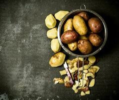 The concept of wet potatoes in the colander on the stone table . Free space for text. photo