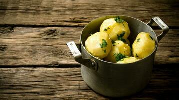 Boiled potatoes with herbs on wooden table . Free space for text. photo