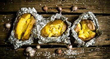 horneado patatas en frustrar en un de madera mesa . foto