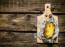 horneado patatas en frustrar en un de madera mesa . foto