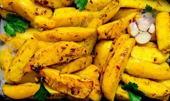 Baked potatoes with spices, garlic and salt. photo