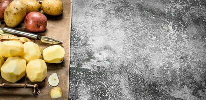 Fresh peeled potatoes in an old tray. photo