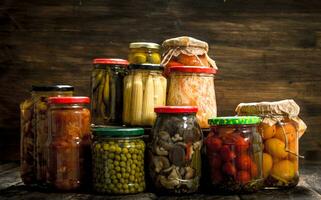 Preserves vegetables and mushrooms in glass jars. photo