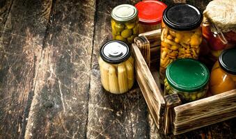 conservas hongos y vegetales en un caja. foto