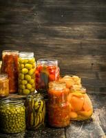 Preserves vegetables and mushrooms in glass jars. photo