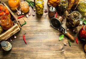 Marinated vegetables and mushrooms in glass jars with seamer. photo