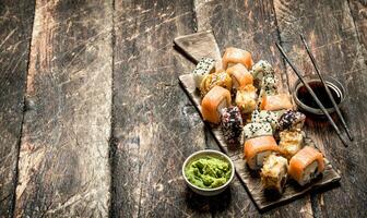 japonés alimento. rollos de Fresco Mariscos con wasabi en el antiguo de madera antecedentes. foto