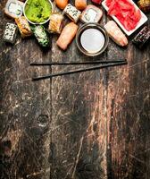 Japanese food. Sushi and rolls fresh seafood with soy sauce. On the old wooden background. photo