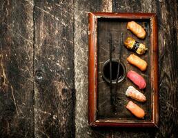 Japanese food. Sushi fresh seafood with soy sauce on an old tray. On the old wooden background. photo