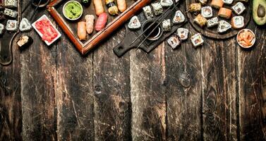 Japanese food. Fresh sushi and rolls with soy sauce. On the old wooden background. photo