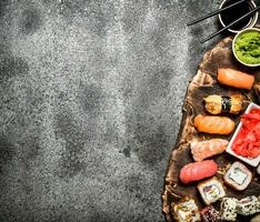 Japanese food. Sushi and rolls fresh seafood with soy sauce and pickled ginger. On rustic background. photo