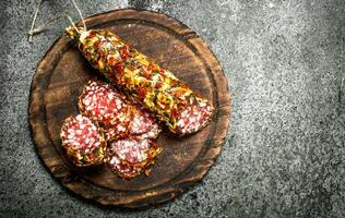 Salami with spices on a cutting board. photo