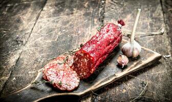 salami with herbs and spices on a board. photo