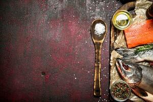 Fresh fish with a piece of fillet and spices. On rustic background. photo