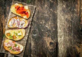 Sandwiches with mushrooms, salami, red caviar and fresh vegetables on toasted bread. photo