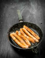 caliente salchichas en un fritura cacerola. foto