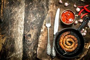 Sausage in a frying pan with tomato sauce and garlic. photo