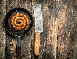 Sausage in a frying pan on the board. photo