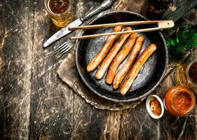 Sausages with cold beer and sauce. photo