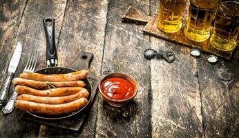 Sausages with cold beer and sauce. photo