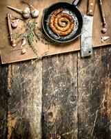 fragrant sausage in a frying pan with a branch of thyme. photo