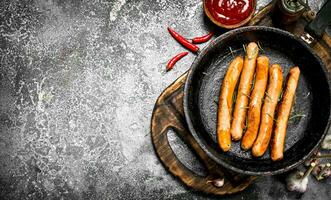 Sausages with tomato sauce on the board. photo