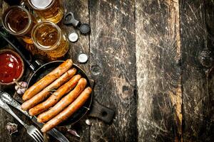 Sausages with cold beer and sauce. photo