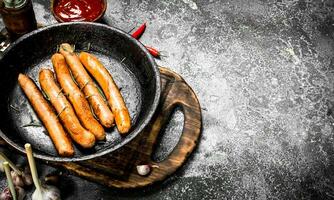 Sausages with tomato sauce on the board. photo