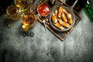 Sausages in a frying pan with a cold beer. photo