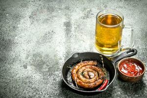 glass of beer with hot sausage. photo