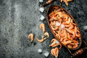 Fresh shrimp in a bowl with ice and fishing net. photo