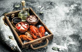Different seafood on a wooden tray. photo