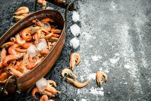 Fresh shrimp in a bowl with ice and fishing net. photo