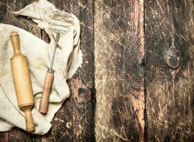 Serving background. Rolling pin and whisk on an old fabric. photo