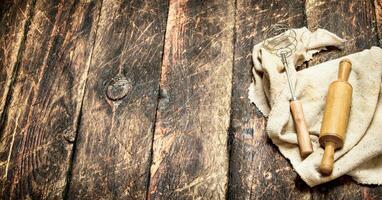 Serving background. Rolling pin and whisk on an old fabric. photo