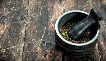 Pepper in a mortar with a pestle. photo