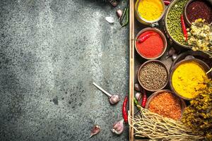 Ground spices in bowls on a wooden tray. photo