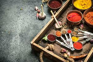 Various spices and herbs in a wooden tray. photo