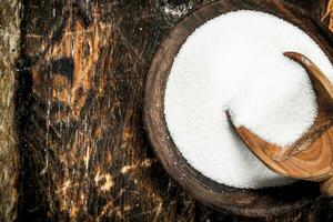 Sugar with a scoop in a bowl. photo