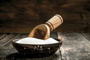 Sugar with a scoop in a bowl. photo