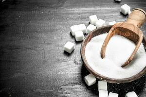 Sugar in a bowl with a scoop. photo