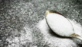 Sugar in a teaspoon. photo