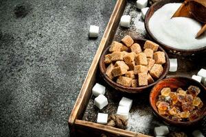 Different kinds of sugar in bowls on a tray. photo